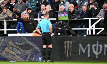 Referee Samuel Barrott checks the pitch-side video assistant referee screen to review a yellow card given to Raúl Jiménez of Fulham during the Premier League match against Newcastle United in December 2023.