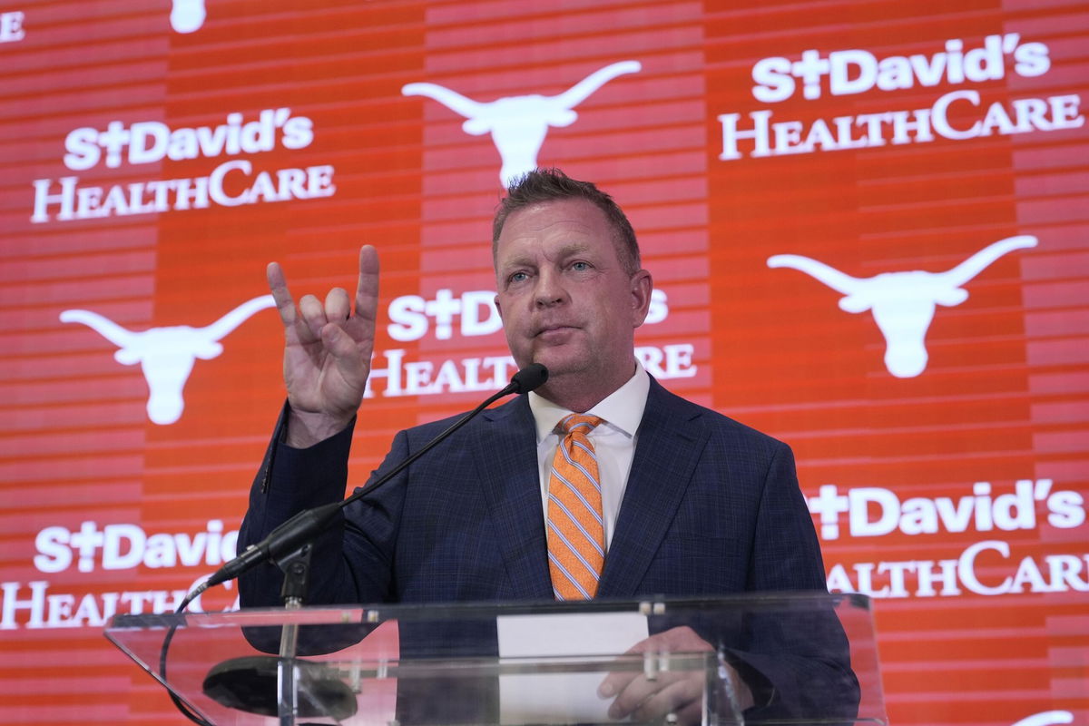 <i>Eric Gay/AP via CNN Newsource</i><br/>Jim Schlossnagle flashes a hook'em sign as he speaks at a news conference after he was introduced as the new NCAA college head baseball coach at Texas