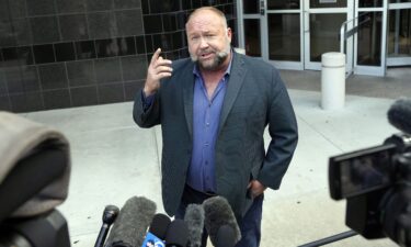 Right-wing conspiracy theorist Alex Jones speaks to the media as he arrives at the federal courthouse for a hearing in front of a bankruptcy judge Friday