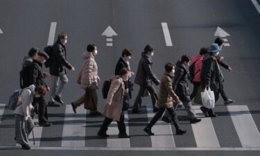 Pedestrians cross an intersection in the Itabashi district of Tokyo