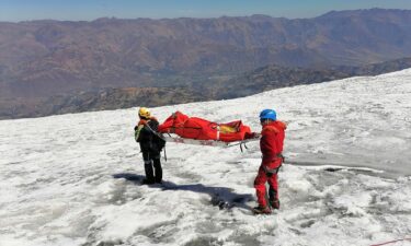 Police carry a body identified as US mountain climber Bill Stampfl