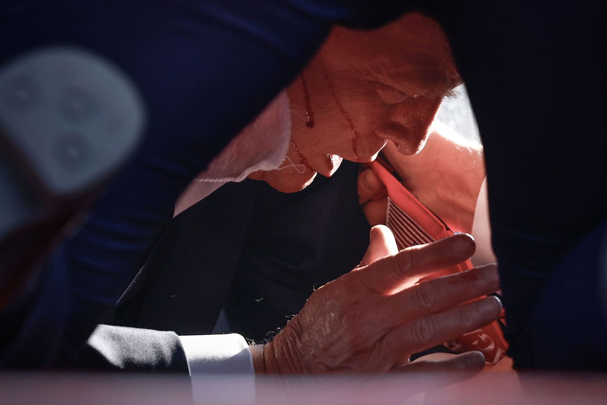 <i>Anna Moneymaker/Getty Images via CNN Newsource</i><br/>Former President Donald Trump is shown covered by Secret Service agents after an incident during a rally on July 13 in Butler