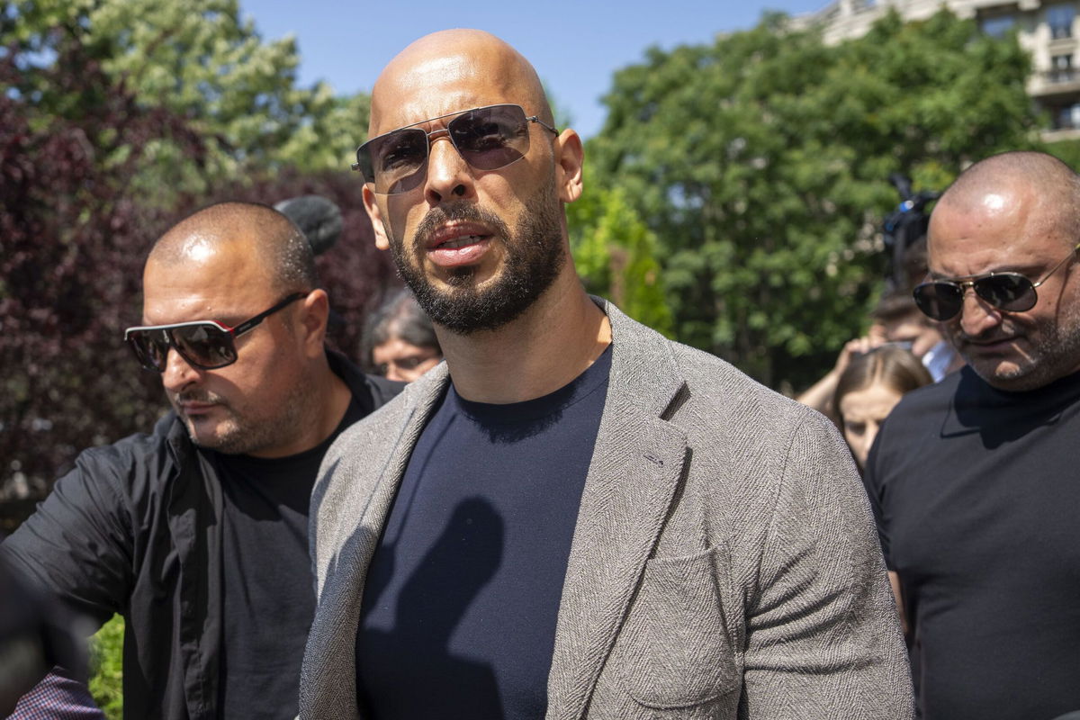 <i>Vadim Ghirda/AP via CNN Newsource</i><br/>Andrew Tate walks between bodyguards in Bucharest