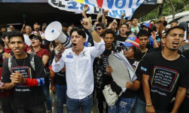 Supporters of Venezuelan President Nicolas Maduro hand out flyers in the neighborhood of Agua de Maiz in Caracas on July 11