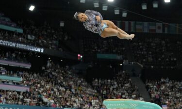 Simone Biles waves as she is joined by members of Team USA after artistic gymnastics women's qualification.