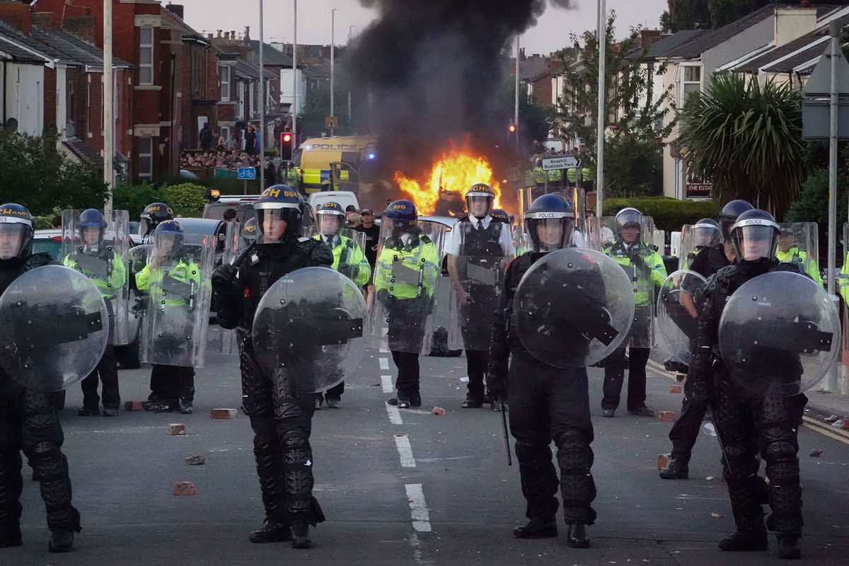 <i>Christopher Furlong/Getty Images via CNN Newsource</i><br/>Riot police hold back protesters after disorder broke out on July 30