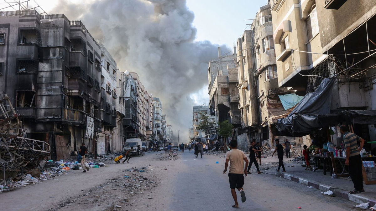 <i>Omar Al-Qattaa/AFP via Getty Images via CNN Newsource</i><br/>Palestinians rush towards a column of smoke billowing following Israeli bombardment which hit a school complex