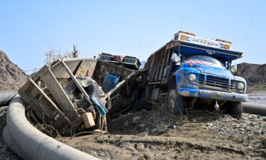 Damaged trucks buried in the mud after the collapse of the Arbaat Dam