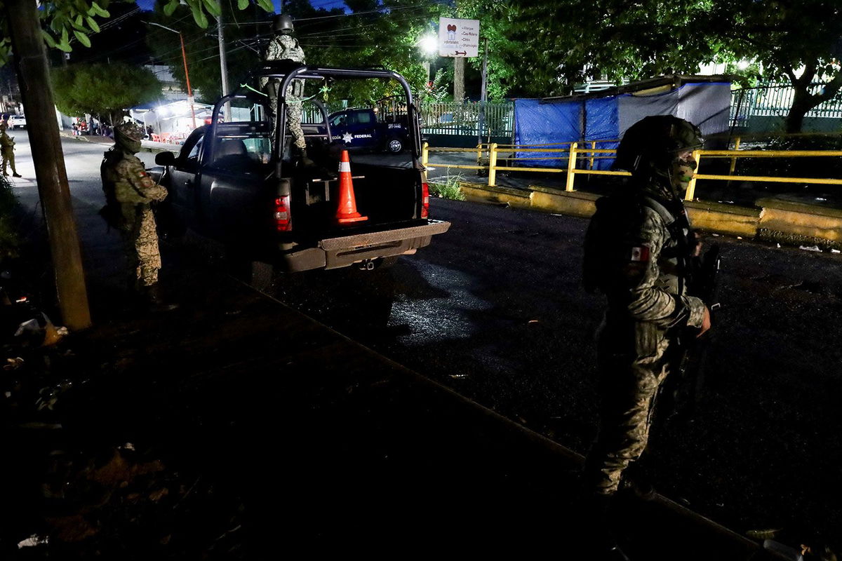 <i>Jose Torres/Reuters via CNN Newsource</i><br/>Soldiers stand guard outside a hospital where injured migrants were taken after Mexican soldiers shot a group of 33 migrants in Tapachula