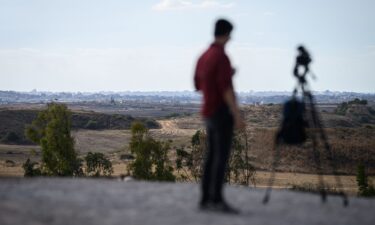 A journalist looks towards Gaza from a viewpoint in Southern Israel on October 7 in Sderot