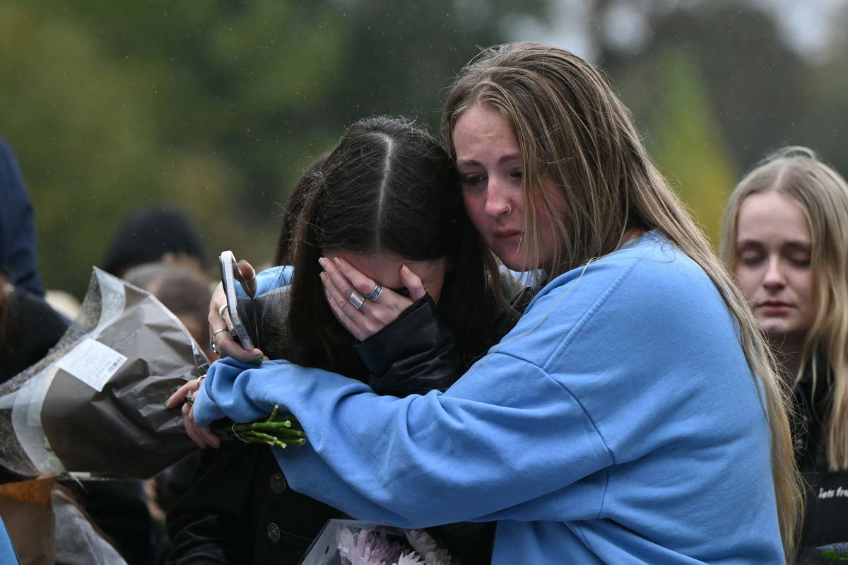 <i>Justin Tallis/AFP/Getty Images via CNN Newsource</i><br/>Fans comforting each other while paying tribute to Liam Payne at a memorial held on Sunday in London's Hyde Park.