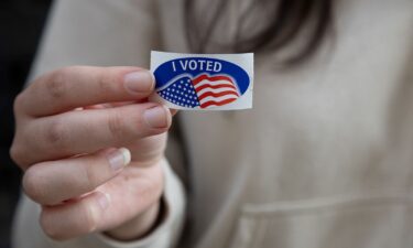 A woman shows off her "I Voted" sticker after dropping off her mail- in ballot at the Allegheny County Office Building in Pittsburgh