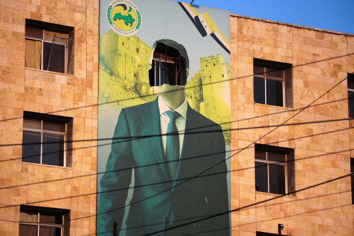 <i>Mahmoud Hassano/Reuters via CNN Newsource</i><br/>A damaged poster of Syrian President Bashar al-Assad in Aleppo after a major attack by rebels who swept into the city on November 30