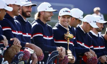 Team USA captain Zach Johnson is pictured holding the trophy alongside Sam Burns and teammates during their team photo.