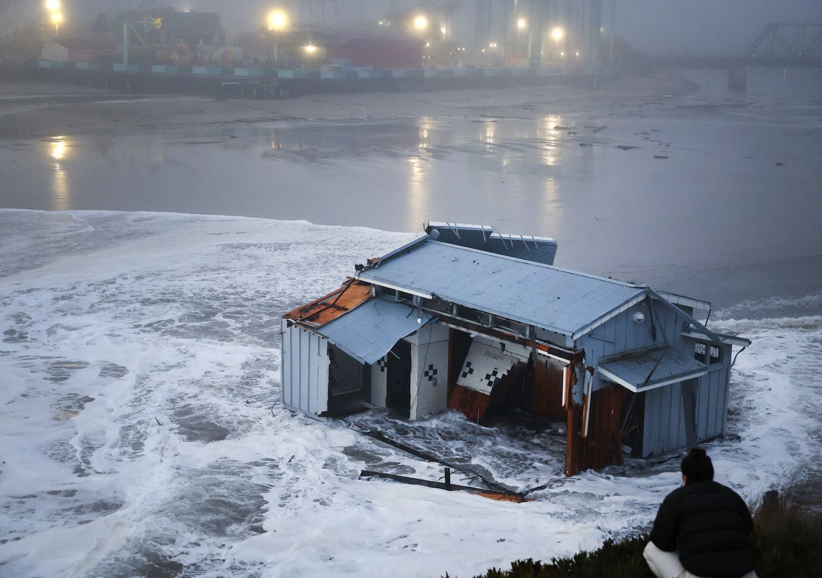 <i>Daniel Dreifuss/AFP/Getty Images via CNN Newsource</i><br/>People look at a portion of the collapsed pier at the Santa Cruz Wharf in Santa Cruz