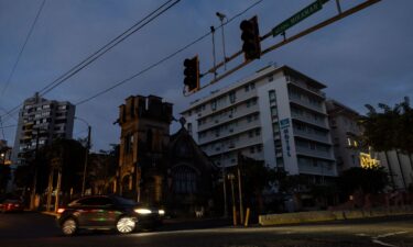 A car navigates an intersection without working stop lights in San Juan