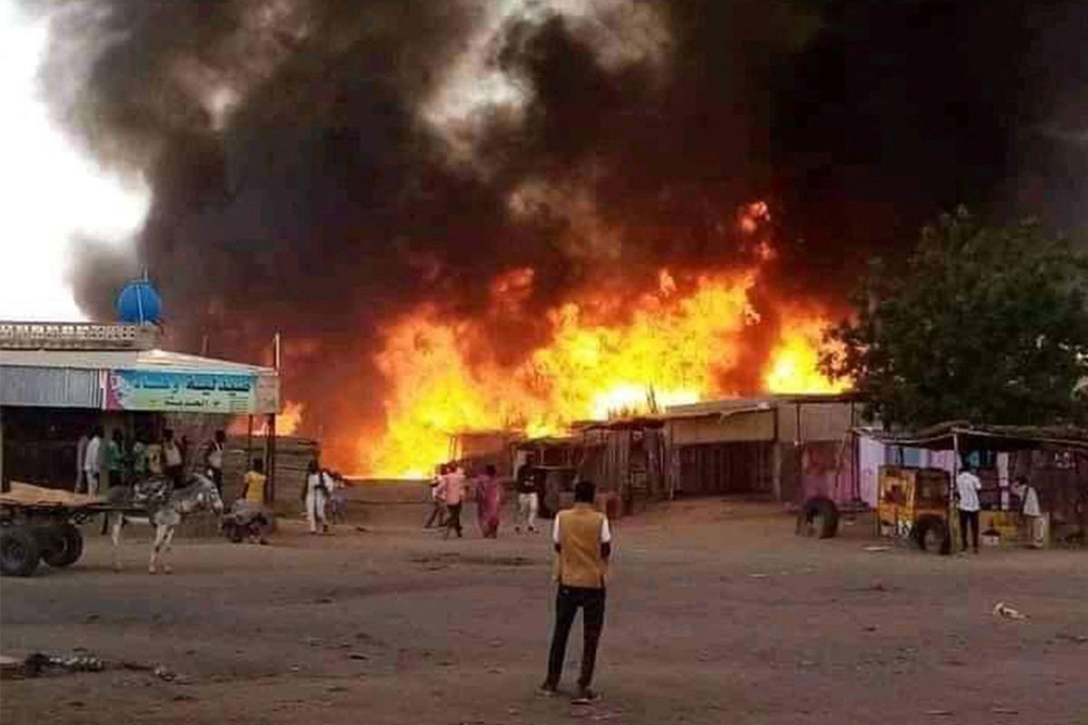 <i>AFP/Getty Images via CNN Newsource</i><br/>A man stands by as a fire rages in a livestock market area in al-Fasher