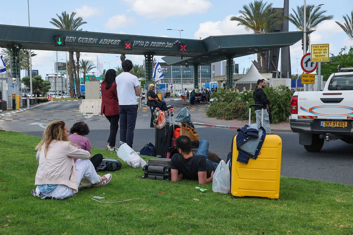 <i>Jack Guez/AFP/Getty Images via CNN Newsource</i><br/>Israeli emergency services clear debris from a road outside Ben Gurion Airport.