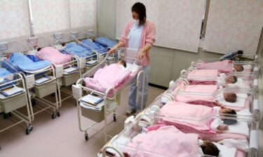 Hospital staff attend to babies in the nursery ward in Misato city