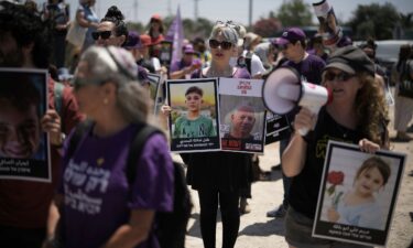 People hold pictures of hostages held by Hamas and children killed by Israeli bombardment in the Gaza Strip at a protest near the Israeli-Gaza border in Sderot