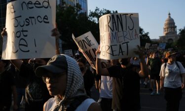 Demonstrators hold signs Monday during a rally in Austin