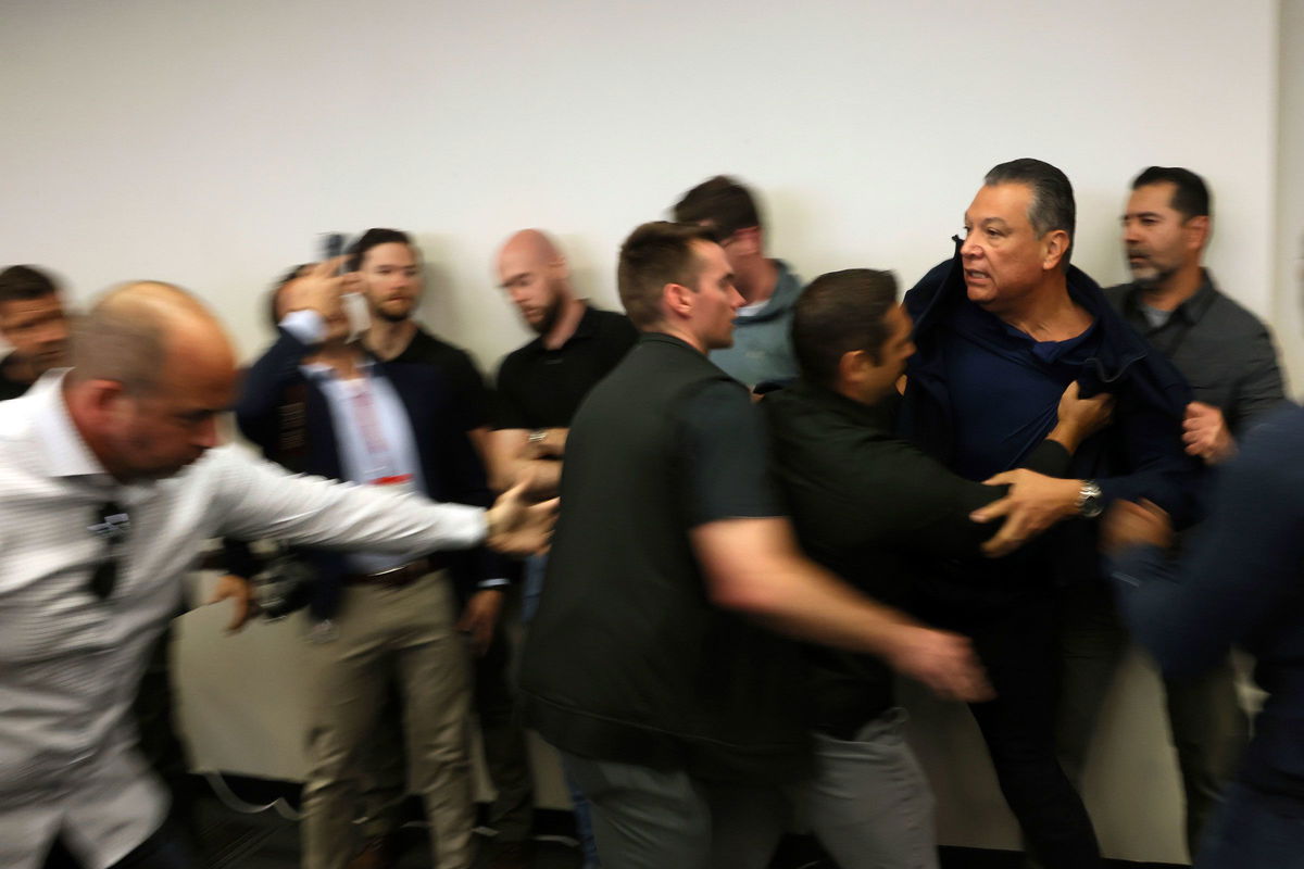 <i>Etienne Laurent/AP via CNN Newsource</i><br/>Sen. Alex Padilla is pushed out of the room as Homeland Security Secretary Kristi Noem holds a news conference regarding the recent protests in Los Angeles on June 12.
