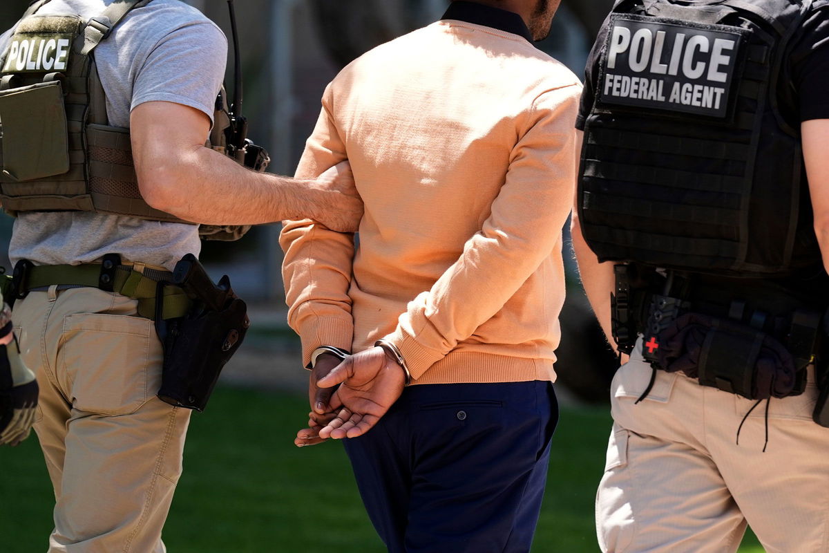 <i>Ross D. Franklin/AP via CNN Newsource</i><br/>Federal agents take a person into custody after an immigration court hearing outside an immigration court on May 21 in Phoenix.