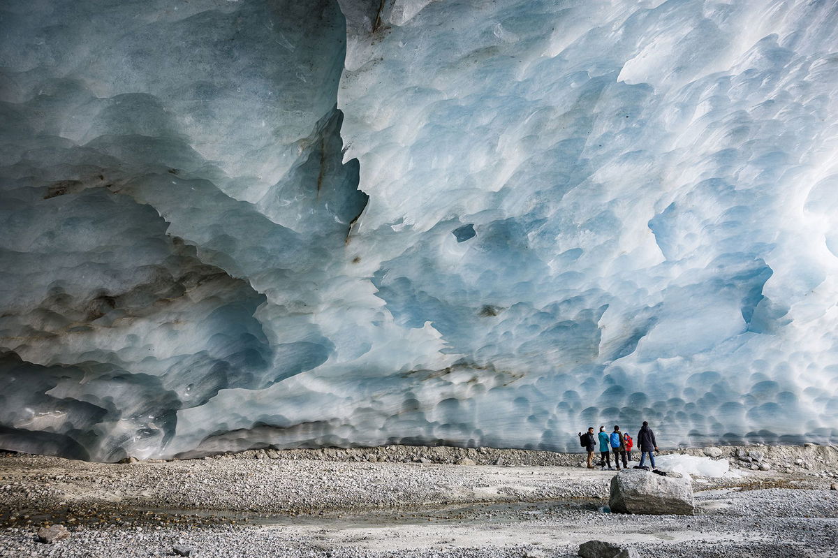 <i>Valentin Flauraud/AP via CNN Newsource</i><br/>Hikers visit an ice cave formed at the end section of the Zinal glacier in Switzerland.