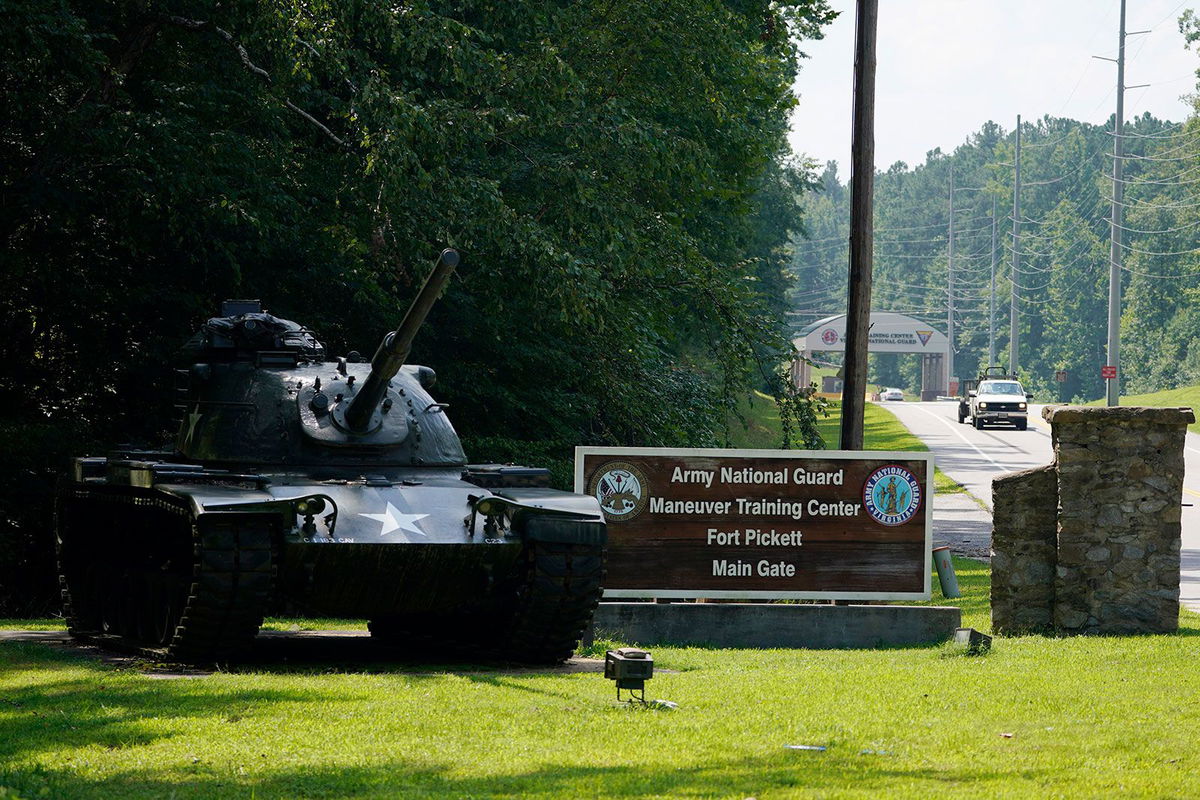 <i>Steve Helber/AP via CNN Newsource</i><br/>Traffic moves toward a tank and sign at the main entrance to Fort Pickett in August 2021