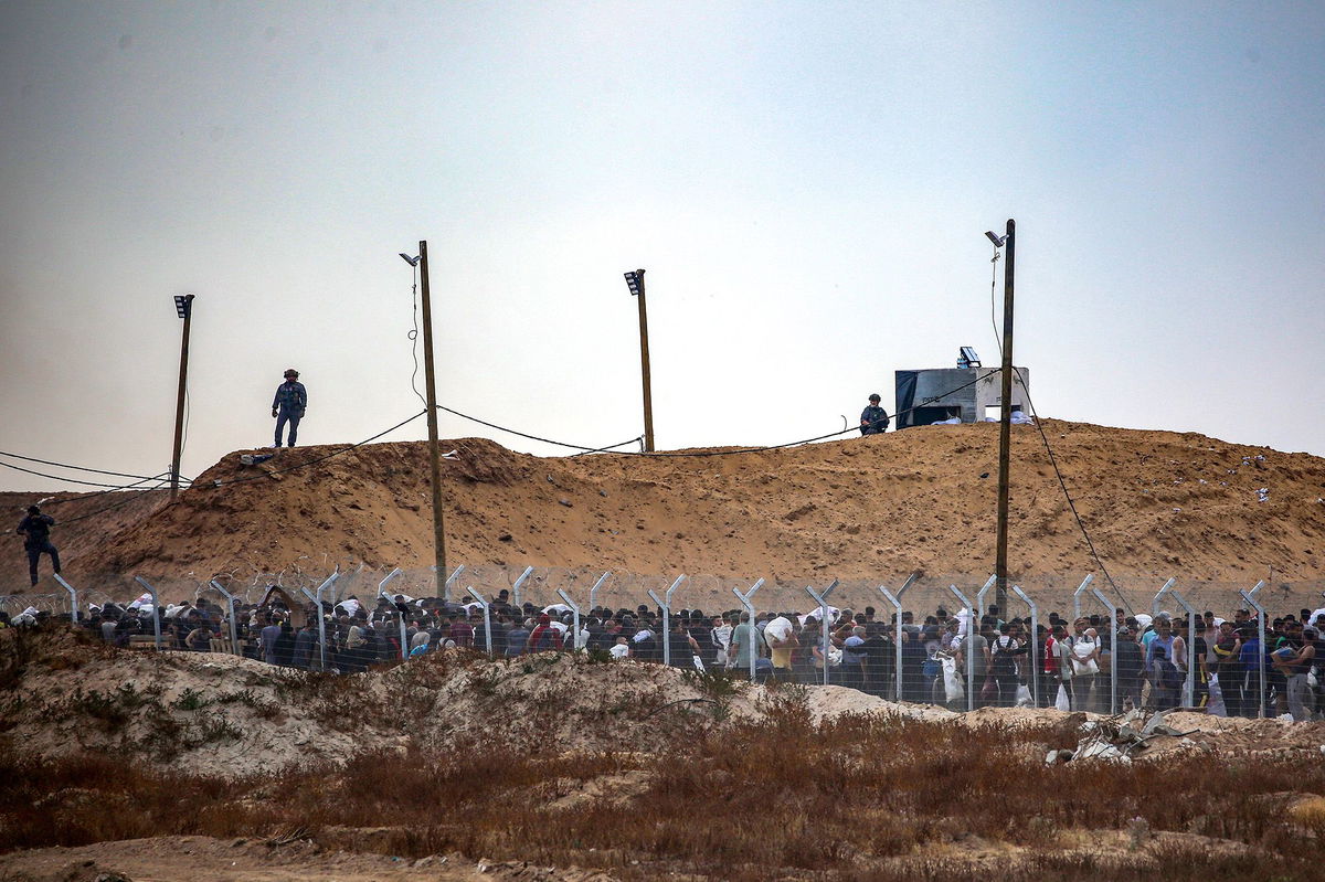 <i>Eyad Baba/AFP/Getty Images via CNN Newsource</i><br/>Members of Gaza Humanitarian Foundation (GHF) direct displaced Palestinians at a distribution centre in central Gaza on June 8.