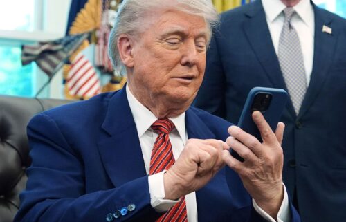 President Donald Trump silences his mobile phone.