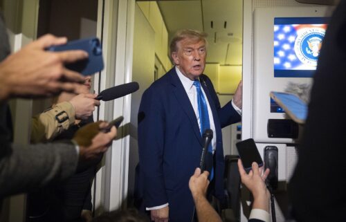 President Donald Trump speaks with reporters while flying aboard Air Force One en route from Calgary