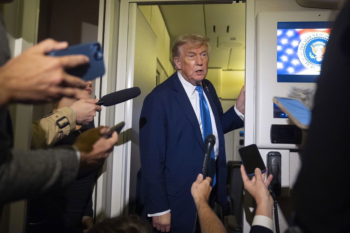 <i>Mark Schiefelbein/AP via CNN Newsource</i><br/>President Donald Trump speaks with reporters while flying aboard Air Force One en route from Calgary