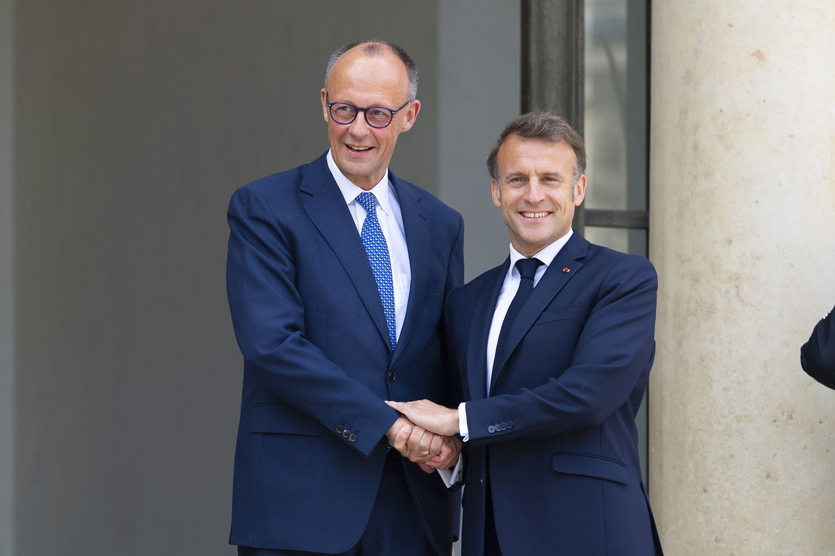 <i>Kin Cheung/Reuters via CNN Newsource</i><br/>French President Emmanuel Macron speaks with Germany's Chancellor Friedrich Merz before a meeting on the sidelines of the NATO summit in The Hague