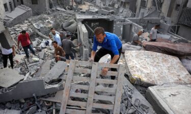 Palestinians search for survivors from the rubble of a home that was hit by an Israeli strike
