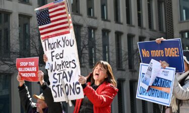 Protesters hold signs in solidarity with the American Federation of Government Employees of District 14 at a rally in support of federal workers at the Office of Personnel Management in Washington