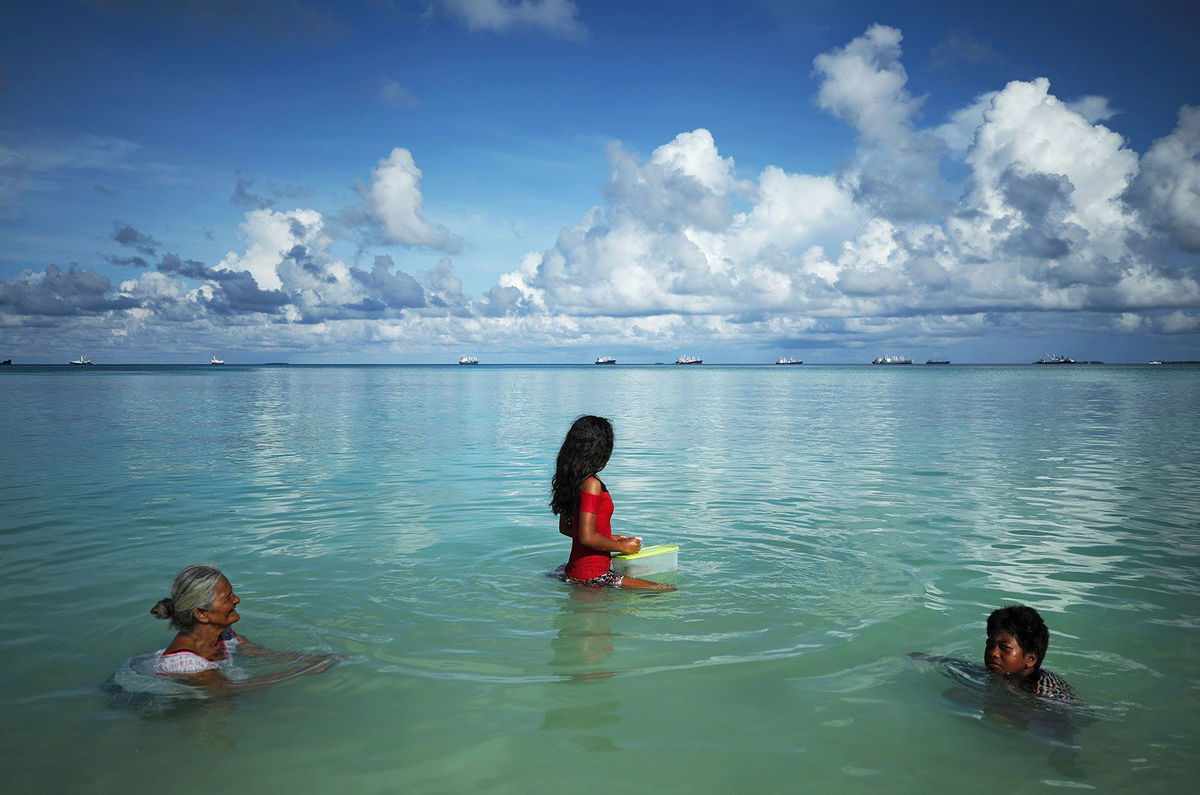 <i>Mario Tama/Getty Images via CNN Newsource</i><br/>People swim in the lagoon in Funafuti