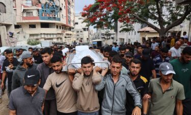 Palestinians carry the body of a man killed a day earlier while attempting to get aid at a distribution point near the Israeli-controlled Zikim border crossing