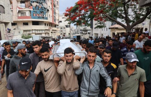 Palestinians carry the body of a man killed a day earlier while attempting to get aid at a distribution point near the Israeli-controlled Zikim border crossing