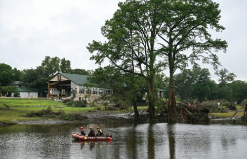 A search and rescue team looks for people along the Guadalupe River near a damaged building at Camp Mystic in Texas