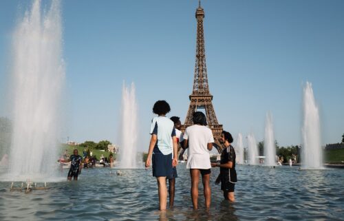 Parisians and tourists cool off at the Trocadero fountain in Paris