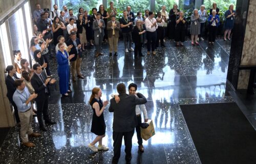 State Department employees applaud as their colleagues walk through the lobby of the State Department headquarters in the Harry S Truman Building