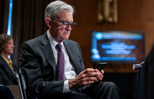Federal Reserve Chair Jerome Powell looks at a phone during a Senate Banking