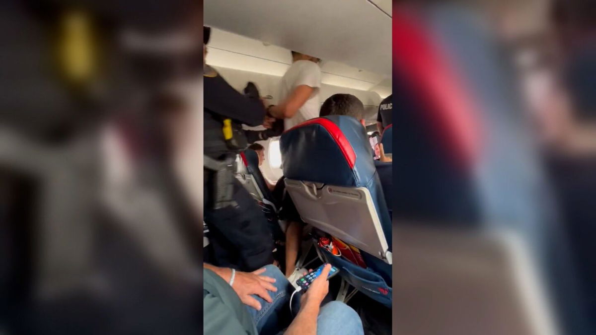 <i>Jonathan Spencer Van der Waarden via CNN Newsource</i><br/>A passenger is escorted off Delta Connection flight 3612 after making an emergency landing in Cedar Rapids