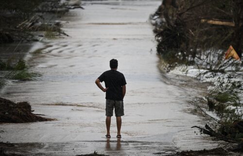 A man looks at a damaged road after severe flash flooding that occurred during the July 4 holiday weekend