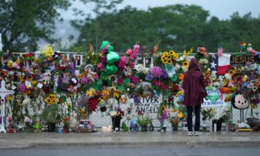 A visitor views a memorial wall for flood victims