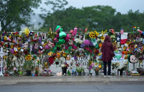 A visitor views a memorial wall for flood victims