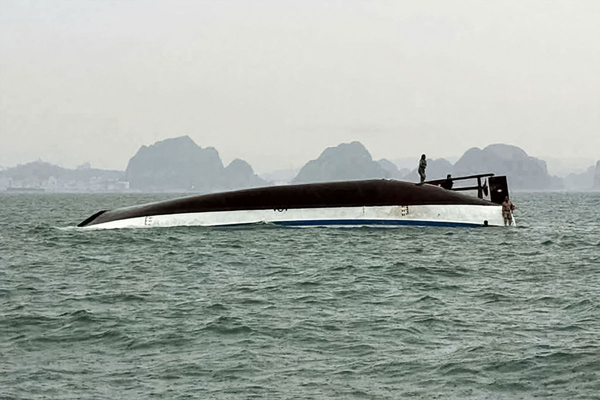 <i>AFP/Getty Images via CNN Newsource</i><br/>People stand on a tourist boat that capsized in Halong Bay on July 19.