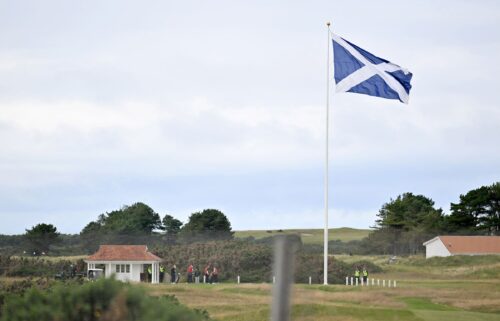 A pro-Trump flag waves in the wind as President Donald Trump arrives at at Prestwick airport