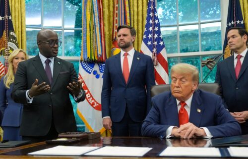 US President Donald Trump listens as Rwanda's foreign minister Olivier Nduhungirehe speaks during an event in the Oval Office at the White House in Washington